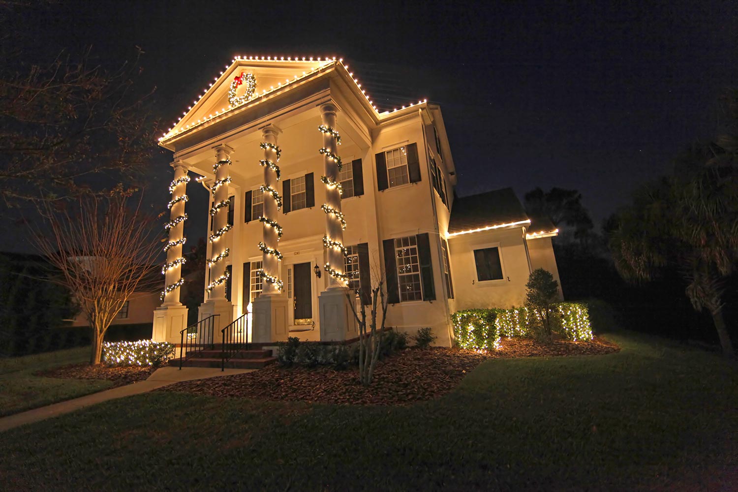 A colonial house with a lot of christmas lights