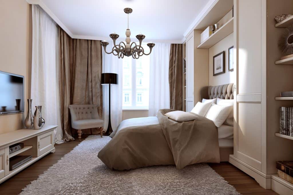 A contemporary styled bedroom with brown white bed and curtains and an area rug under the bed