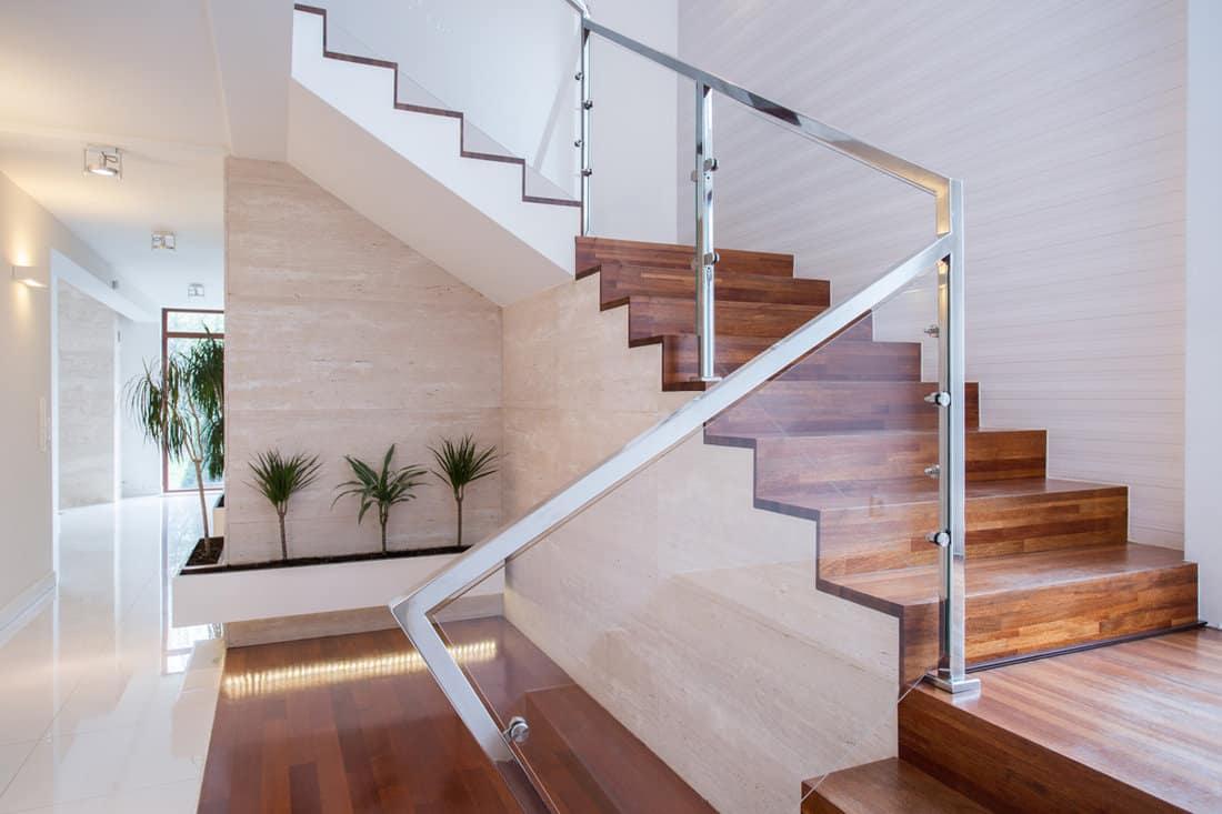 A gorgeous hallway with modern designed glass walled staircase