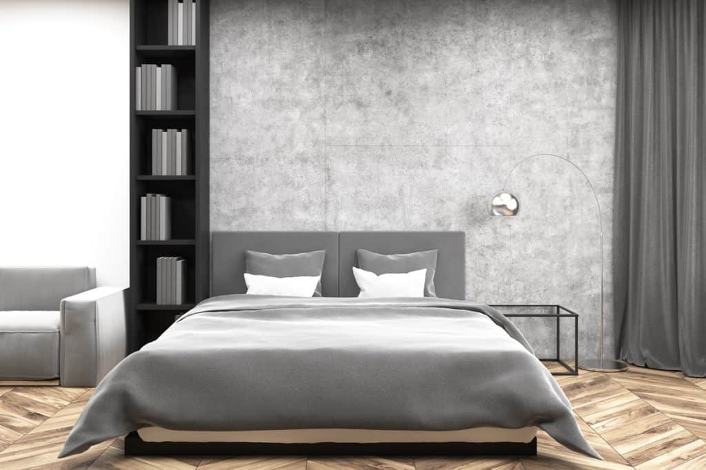 A gray inspired bedroom with gray bedding sets, a gray foam dashboard, and a black divider with gray books