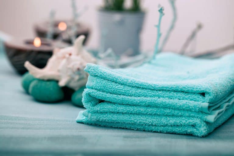 Light blue colored bath towel in a hotel room, How Big Is A Bath Towel? [Standard Towel Sizes With Chart]