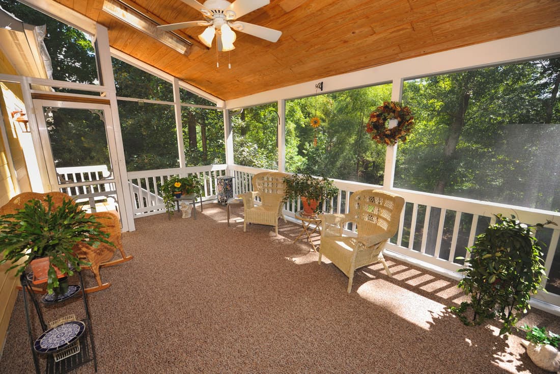 A-screened-in-porch-with-plants-and-chairs-for-featured, How To Cover Porch Windows? 6 Awesome Ideas!