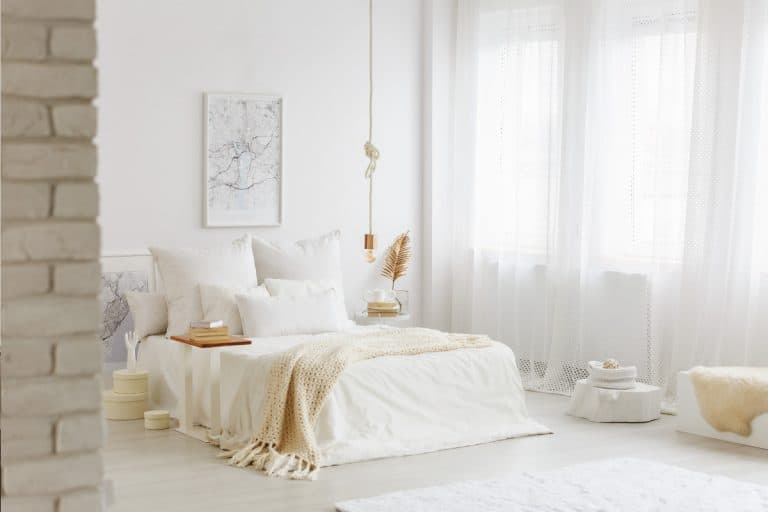 Bed with white bedding in spacious bedroom interior with gold decorations and big window with airy curtains, 12 Best Fabrics For Curtains [Sheer & Opaque]