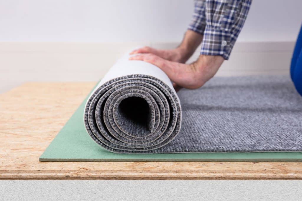 Close-up of a male worker's hand installing carpet