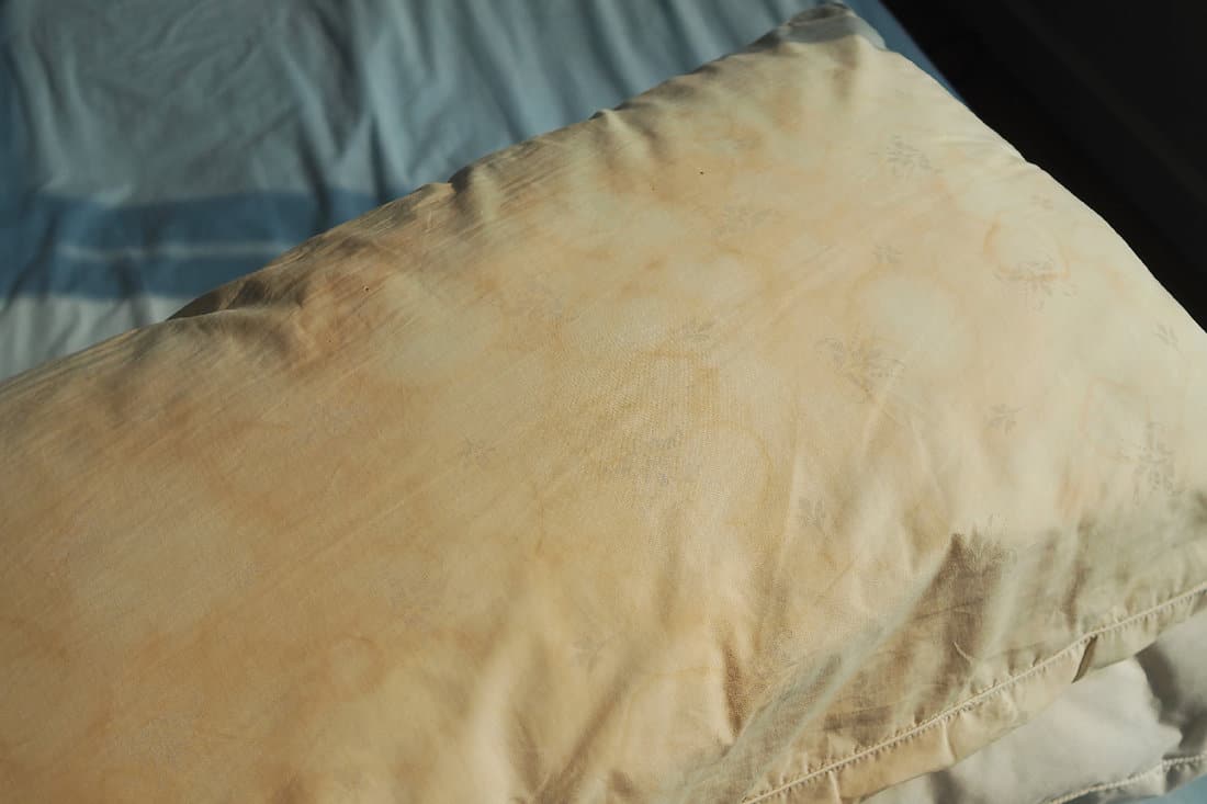 Dirty pillow from saliva stain on the bed