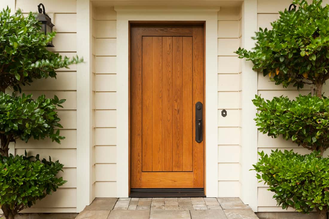 Front door of a house made from hardwood and a metal door knob