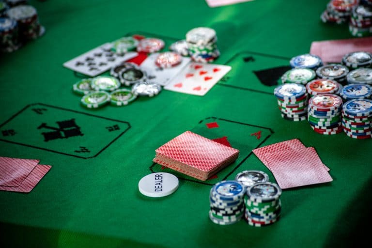 Gambling cards and chips scattered on a card table, What is the Standard Size of a Card Table?