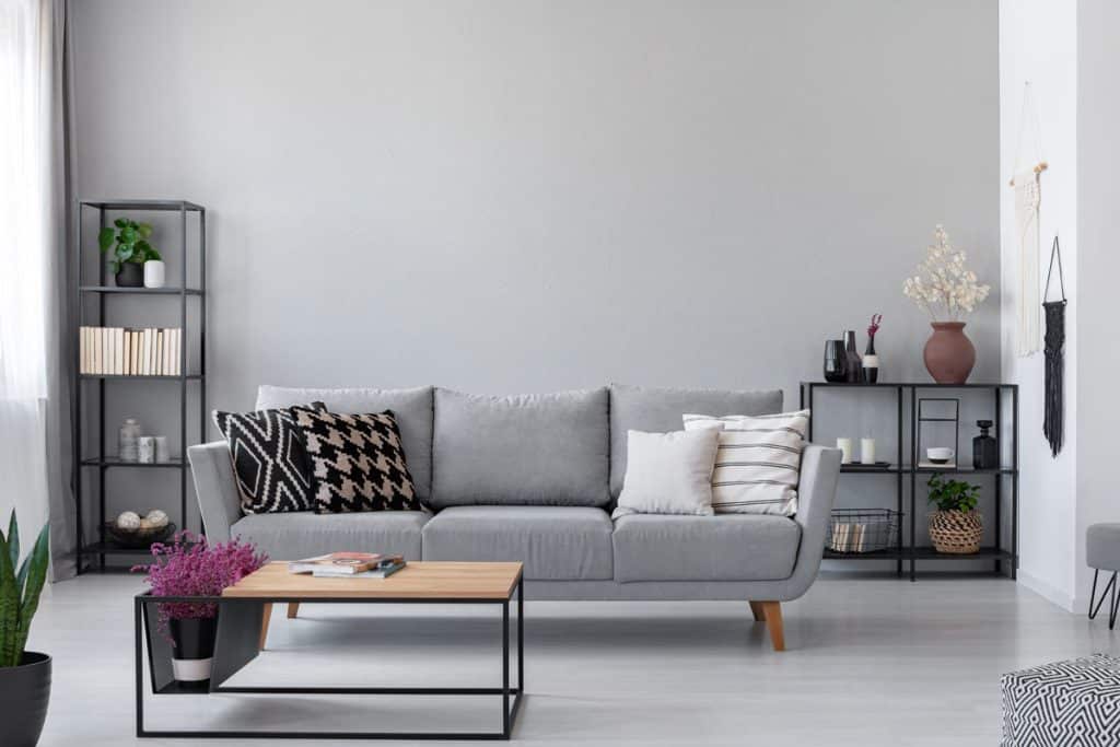 Gray sofa with patterned throw pillows inside a grey living room