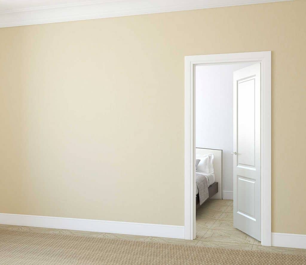 Hallway with plain walls with open door to a bedroom