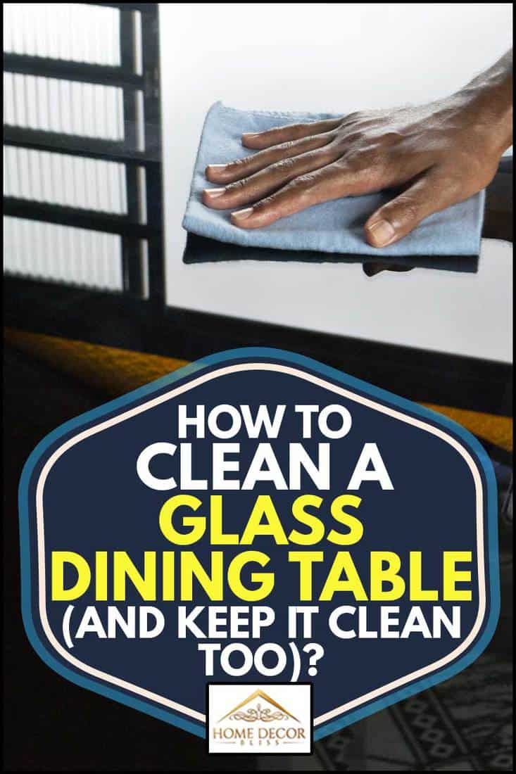 Une main d'homme nettoyant une table à manger en verre, Comment nettoyer une table à manger en verre (et la garder propre aussi) ?