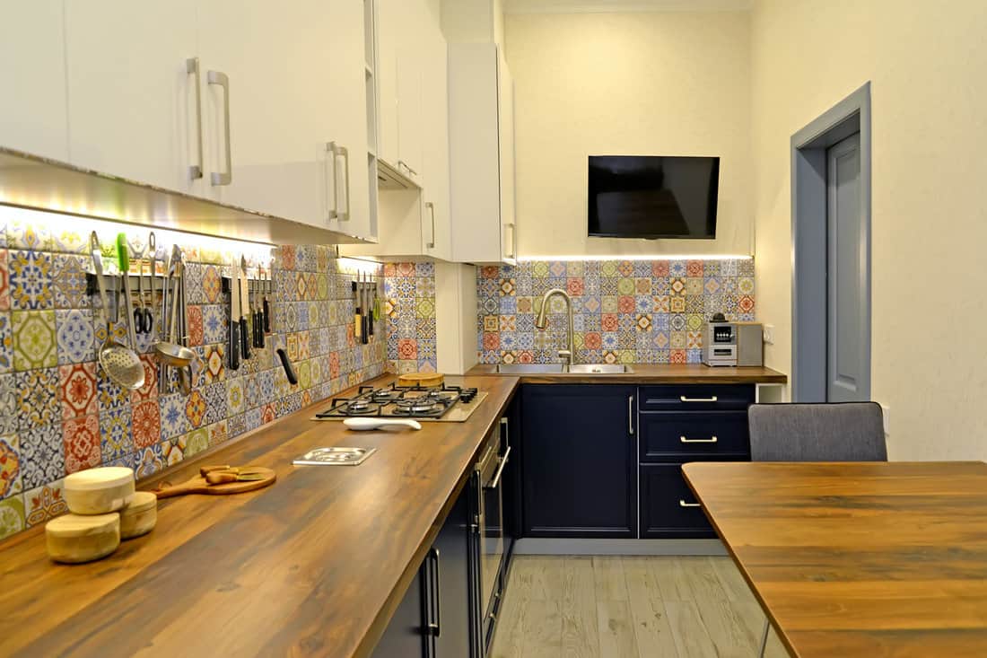 Interior of a modern kitchen with a TV on the wall