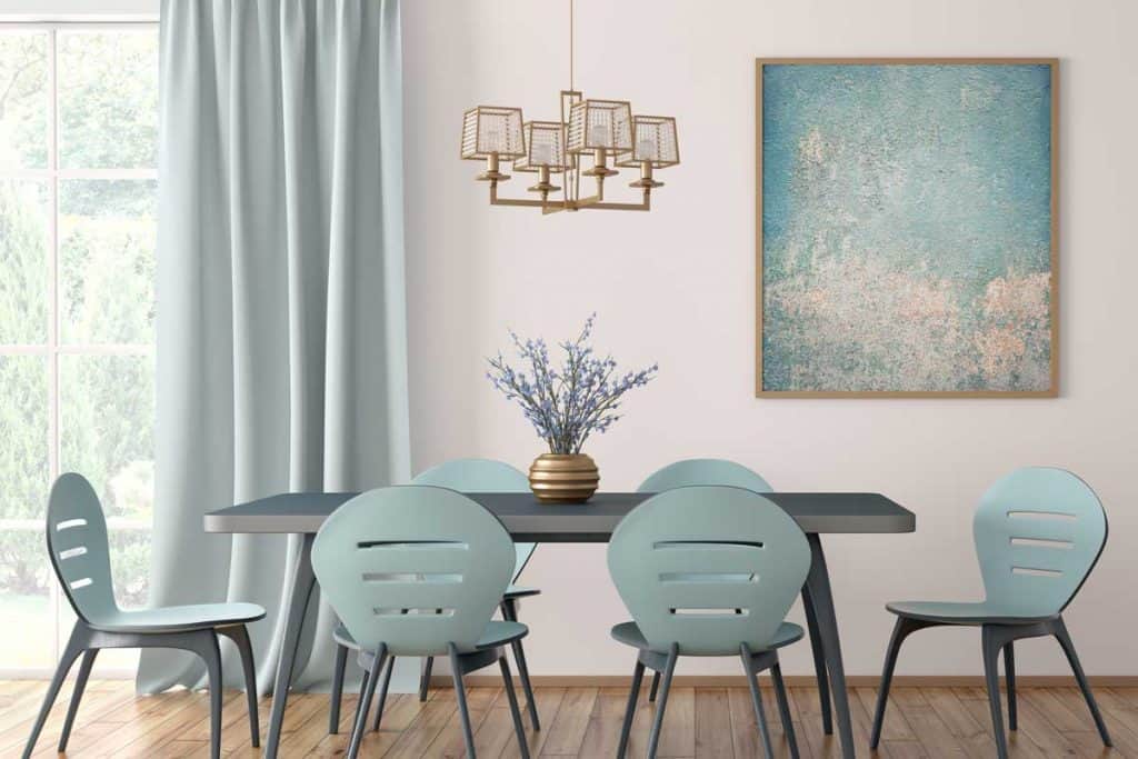 Intérieur de la salle à manger moderne avec table et chaises bleues contre un mur blanc avec grande fenêtre et rideau