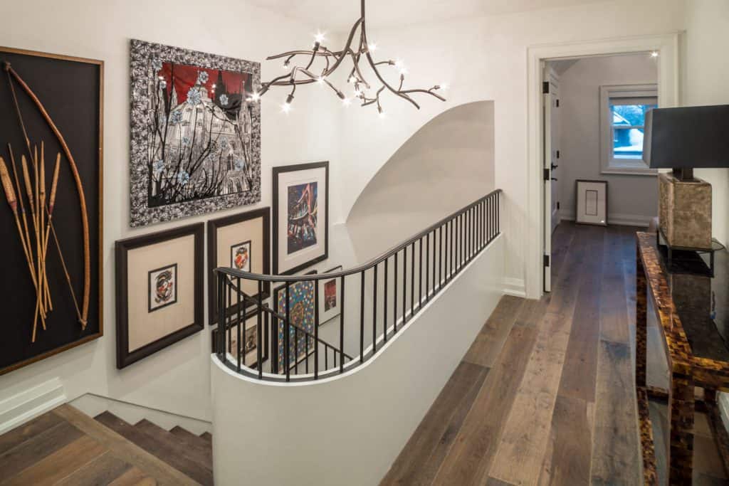 Grand stairs with hanging wall decor in modern hallway interior