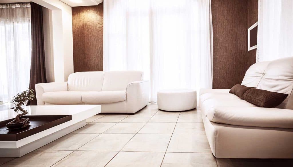Salon d'appartement de luxe avec des canapés blancs confortables et un sol carrelé