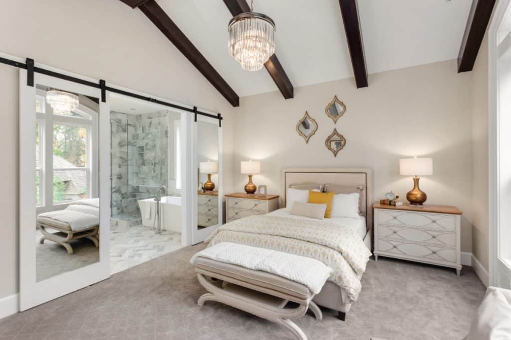 Master bedroom in new luxury home with chandelier and carpet