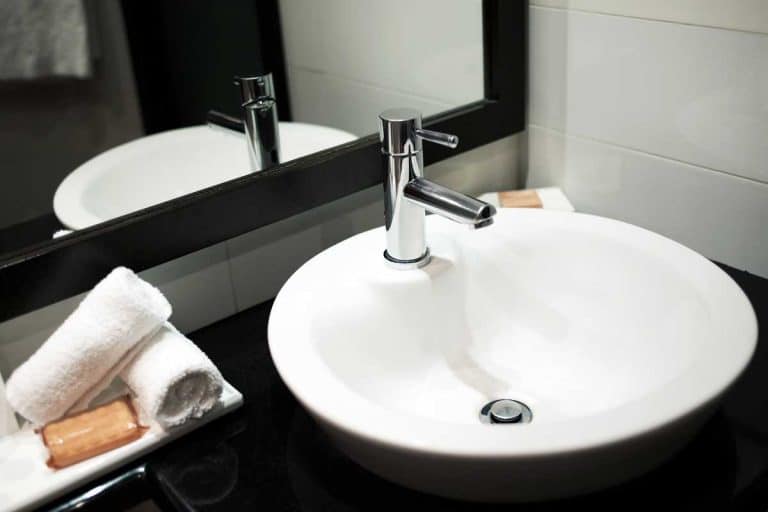 Modern bathroom sink with mirror reflection - with towels top view, How Far Should A Faucet Extend Into The Bathroom Sink?