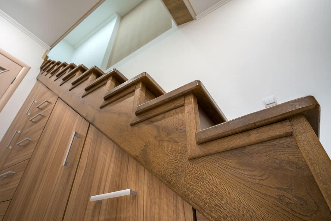 Oak wooden stairs with modified cabinets underneath