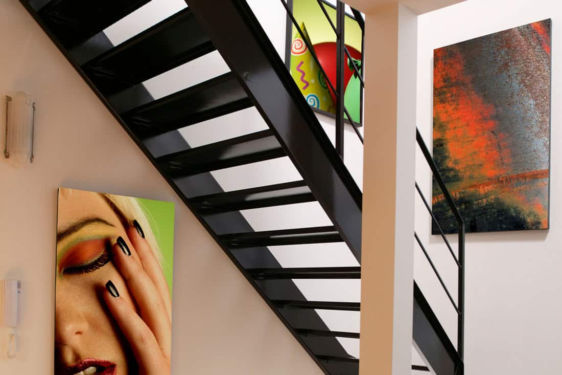 Residential steel staircase with hanging paintings on the wall
