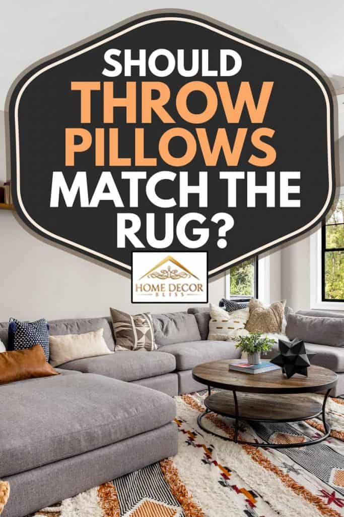 Salon avec canapé d'angle gris dans une maison de luxe nouvellement construite, les coussins doivent-ils correspondre au tapis ?