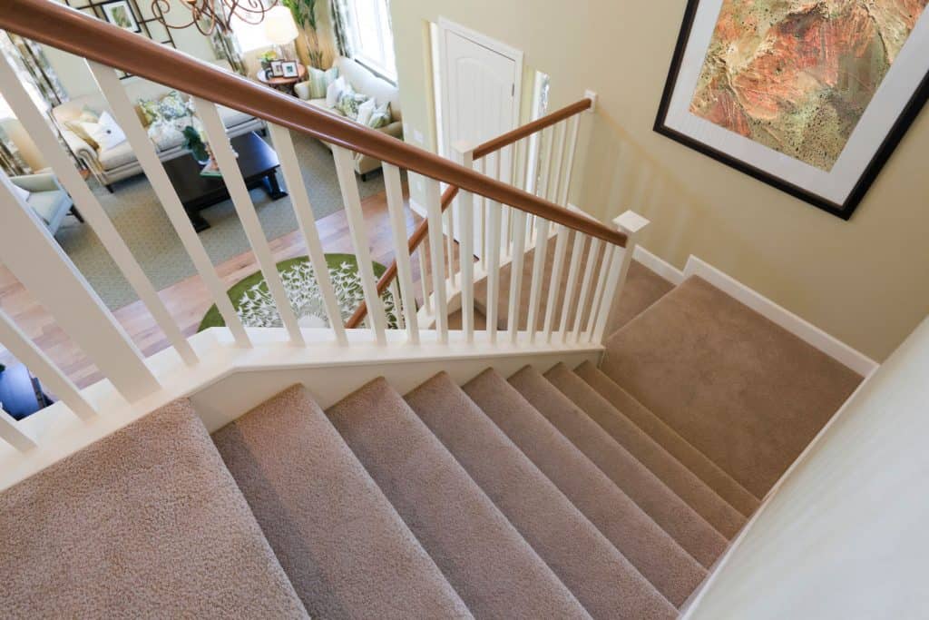 A view down interior carpeted stairs in a modern American home