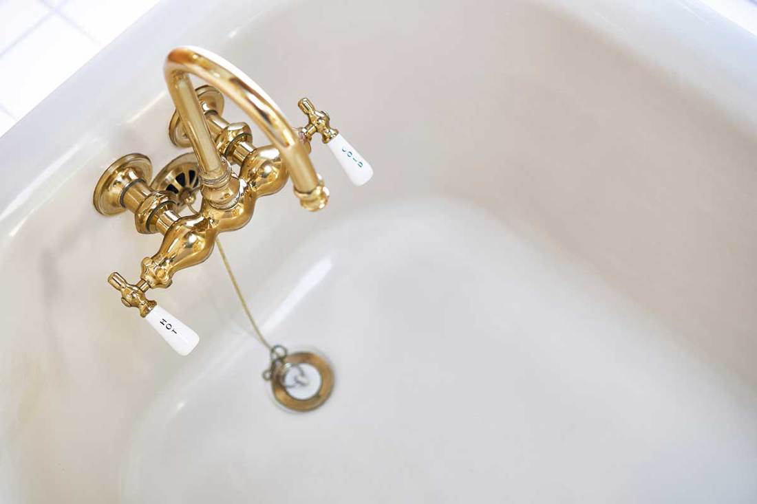 Vintage brass faucet in bathtub in old home in California