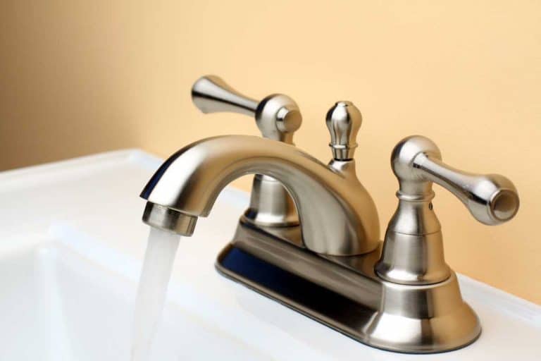 Water-flowing-from-brushed-nickel-faucet-on-white-porcelain-bathroom-sink-768x512.jpg