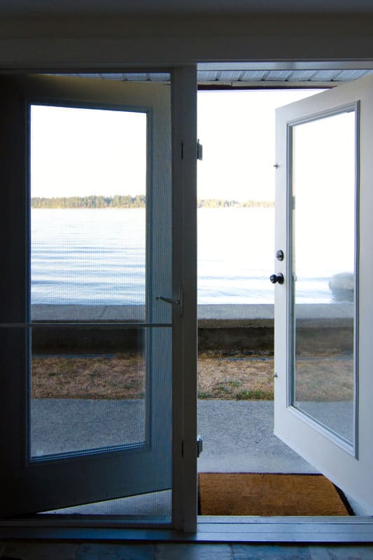 White opened French door leading to the view of the lake outside