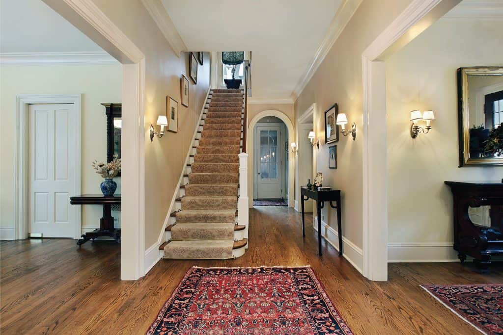 Carpeted stairs in suburban home with wooden handrails