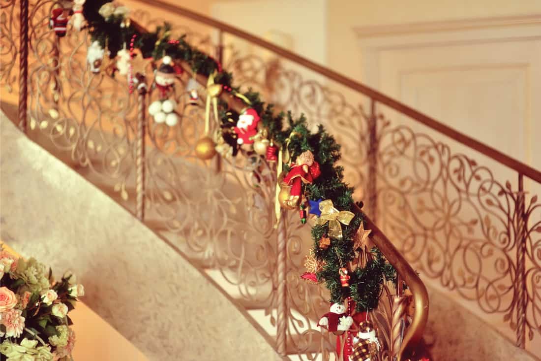 decorated metal handrails for the holidays, how to hang garland on a staircase [3 easy ways]