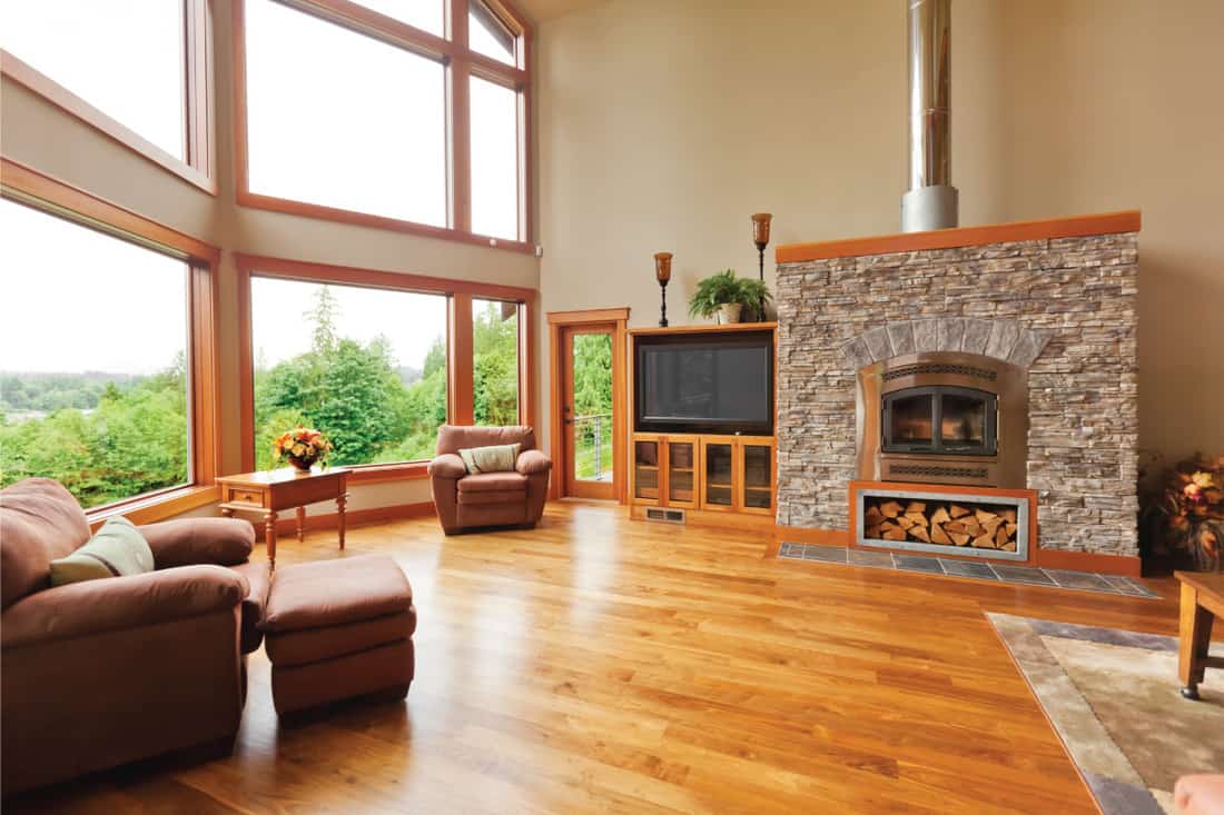 great living room with extra large windows fireplace and a wooden flooring, is carpet cheaper than laminate or wood