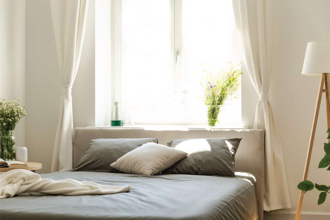 Light shining through open linen curtains in a bedroom