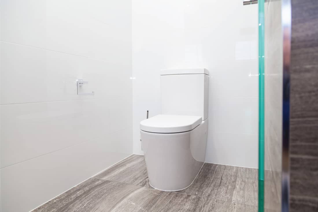 Modern white toilet with flooring underneath