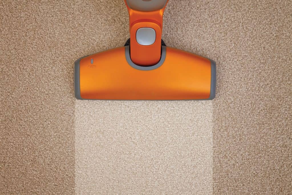 Orange vacuum cleaner cleaning a carpet really well