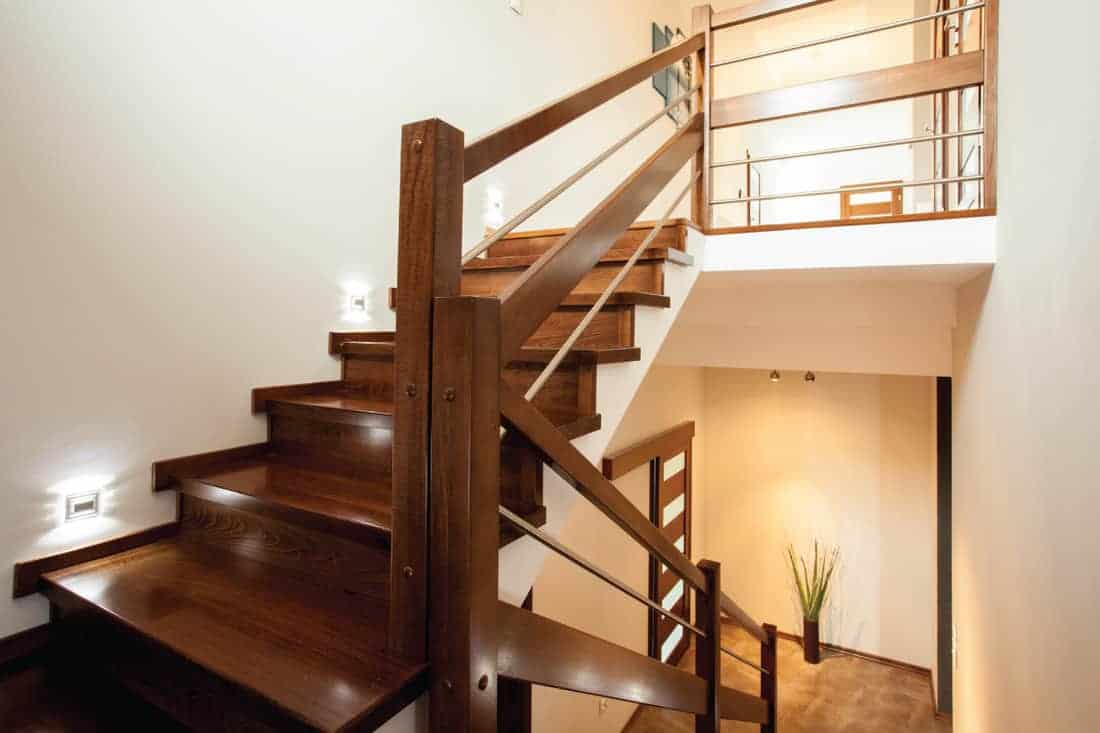well lighted wooden stairs at home with handrails