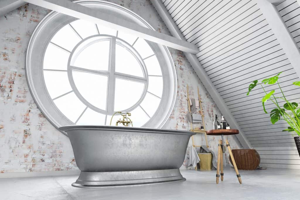 A bathroom on the attic of a house painted in gray with an indoor plant on the side