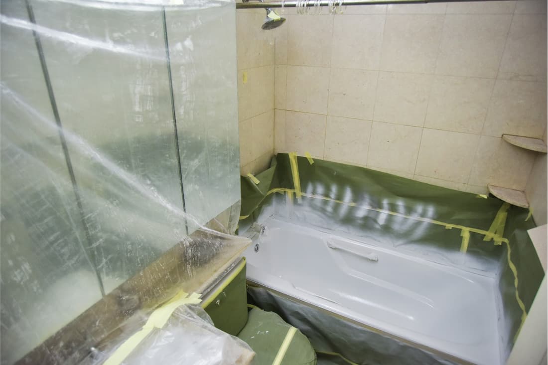 Une salle de bain en cours de rénovation avec baignoire en cours de reglaçage