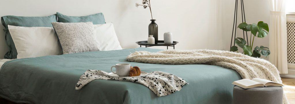 Un lit avec des draps sales, du café inachevé et une couverture sale