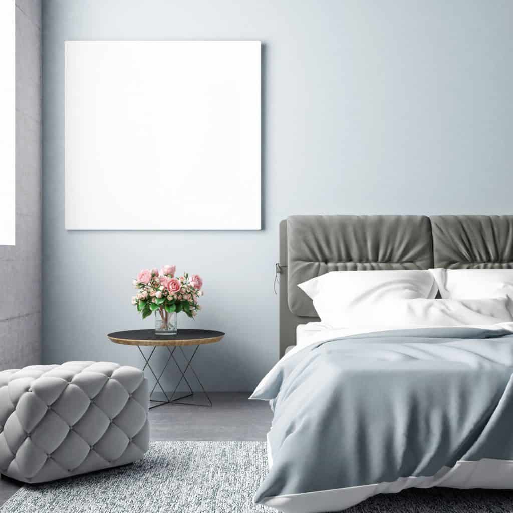 A blue walled living room with a white canvas hanged on the wall and a bed with gray and white beddings, What Color Carpet Goes With Blue Walls, What Color Carpet Goes With Blue Walls