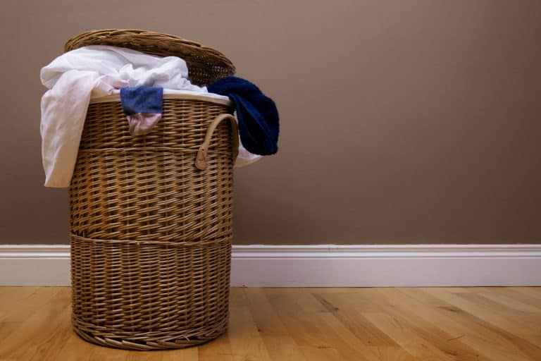Brown laundry basket placed on the side of a room, Where To Keep Your Laundry Basket [4 Great Options]