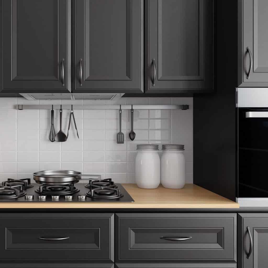 Un comptoir de cuisine avec des armoires à panneaux noirs et un comptoir de couleur crème