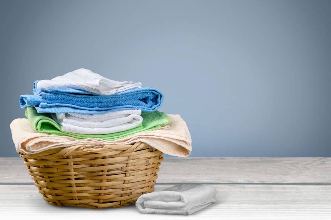 A laundry basket filled with newly washed laundry, How To Keep Your Laundry Basket Smelling Fresh