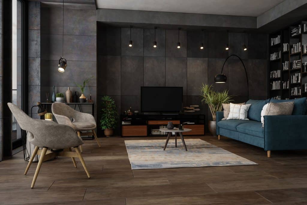 A luxurious modern living room decorated with gray tiled walls, wooden laminated flooring, modern couches and chairs