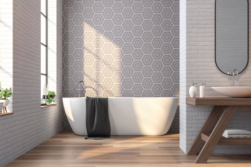 A modern bathroom with a patterned wallpaper and a white bathtub