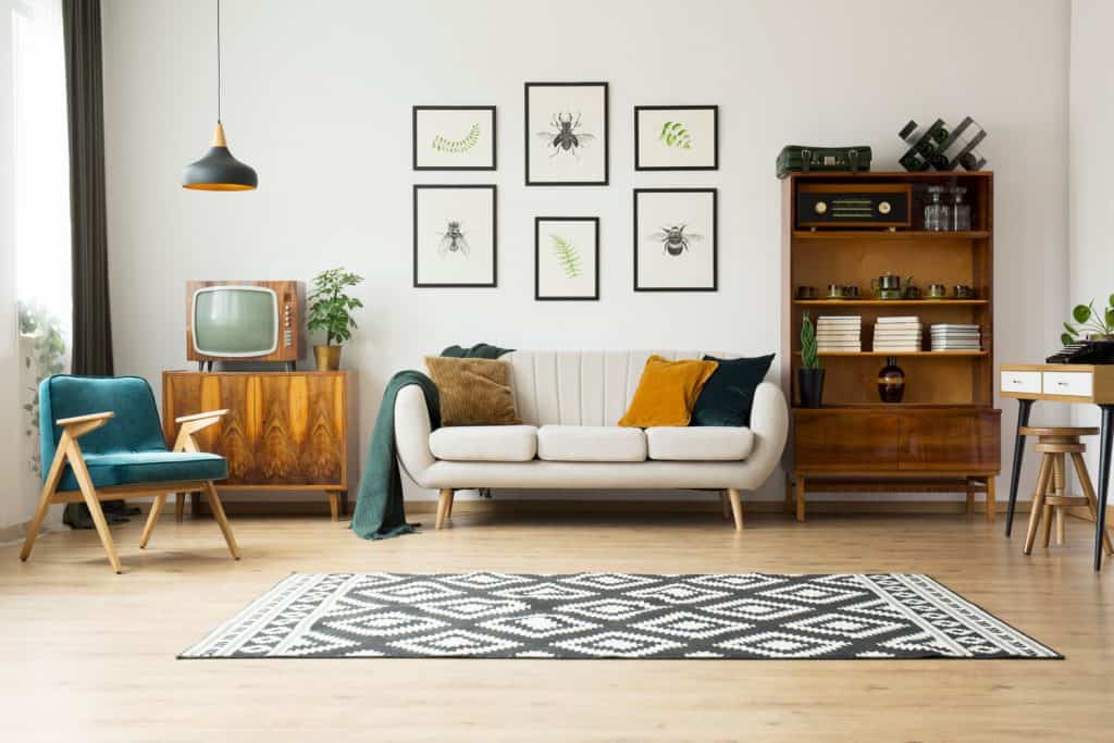 A modern retro themed living room with wooden furniture, white couch and a black and white patterned rug
