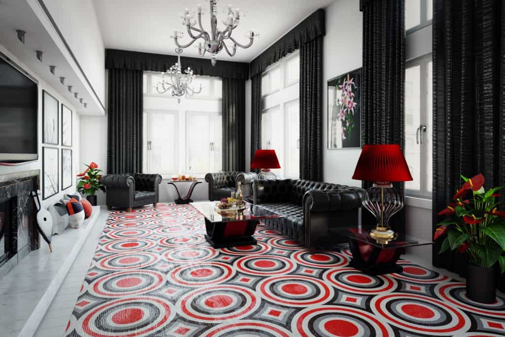 A spacious black and white themed living room with black sofas, black curtains, and a red-gray patterned rug