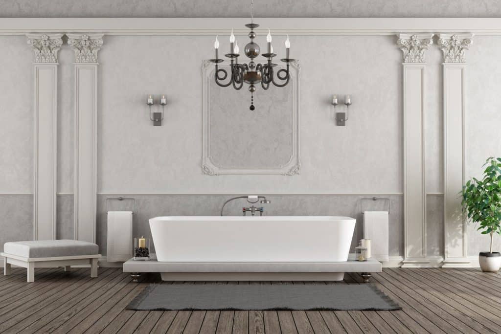 A white and gray themed bathroom incorporated with class molding on the columns
