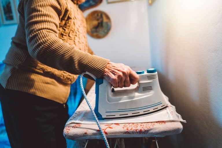 Elderly woman ironing her newly washed curtains, How To Iron Curtains