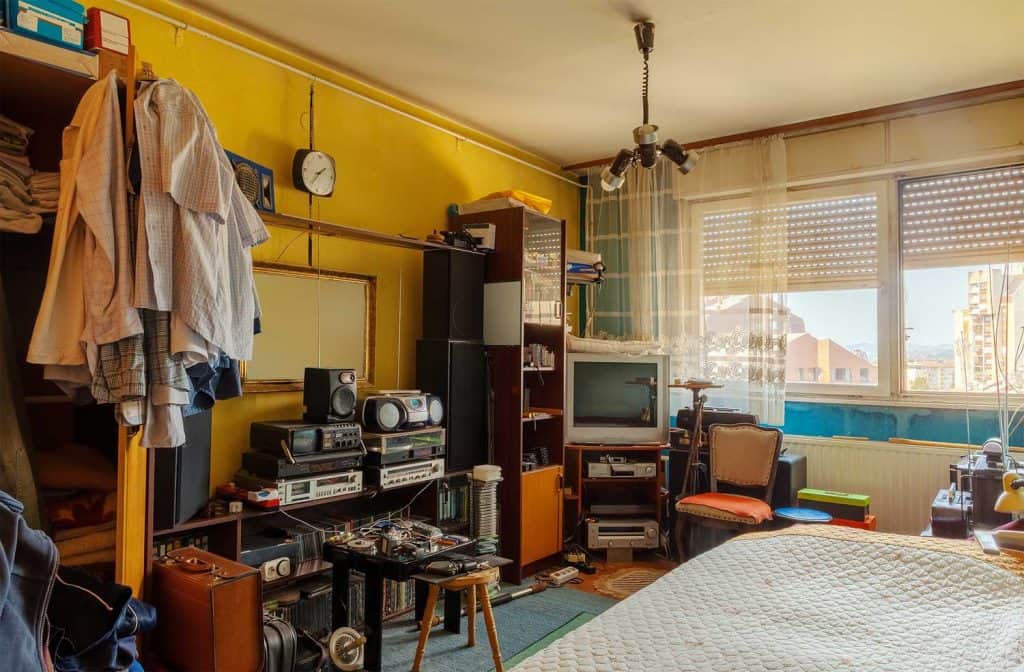 An old retro room interior with a lot of various retro technology equipment and personal things