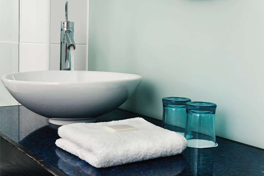 Bathroom sink counter with towel and drinking glass
