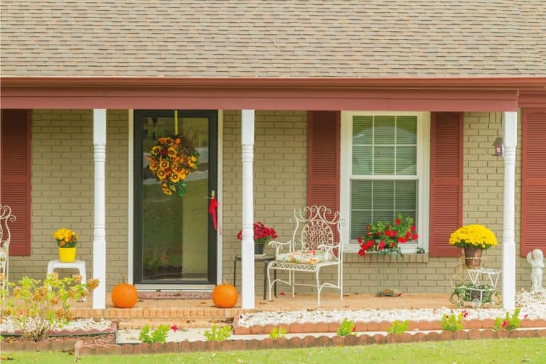 Beautiful house decorated for Halloween with pumpkins and seasonal flowers, 15 Awesome Porch Wall Decor Ideas
